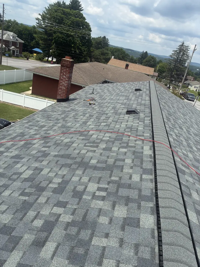 Grey architectural asphalt shingle roof with a ridge vent running the full length of the ridge.