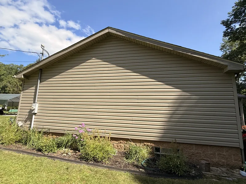 Tan horizontal lap siding across a gable end, with a matching soffit and fascia.
